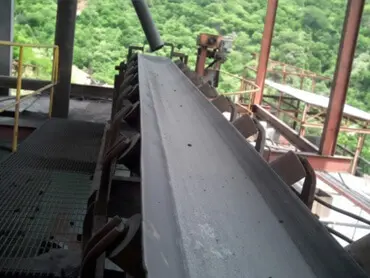 Rollo de hule minero resistente con piedras sobre fondo de mina